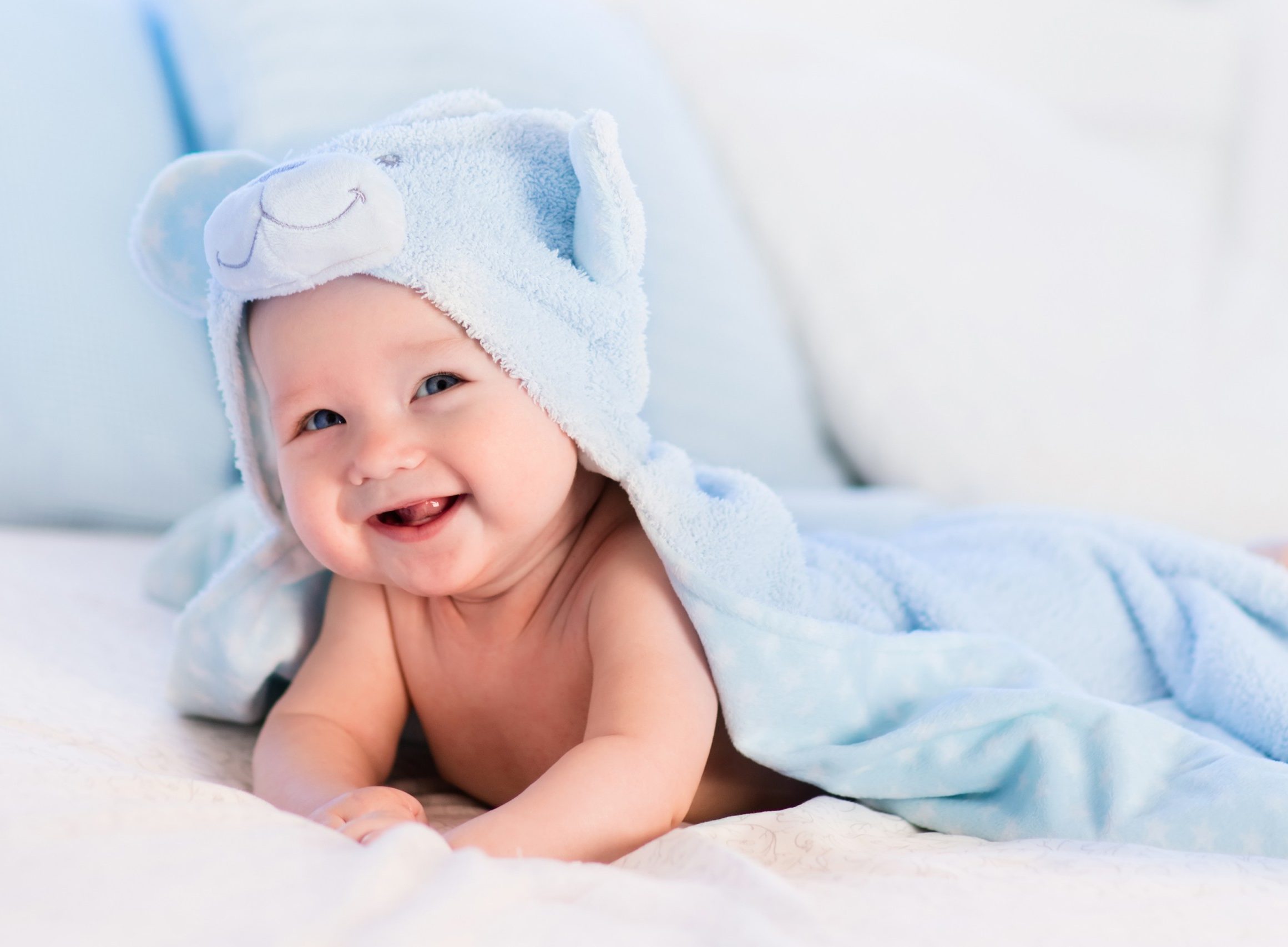 smiling baby with bath towel over the head
